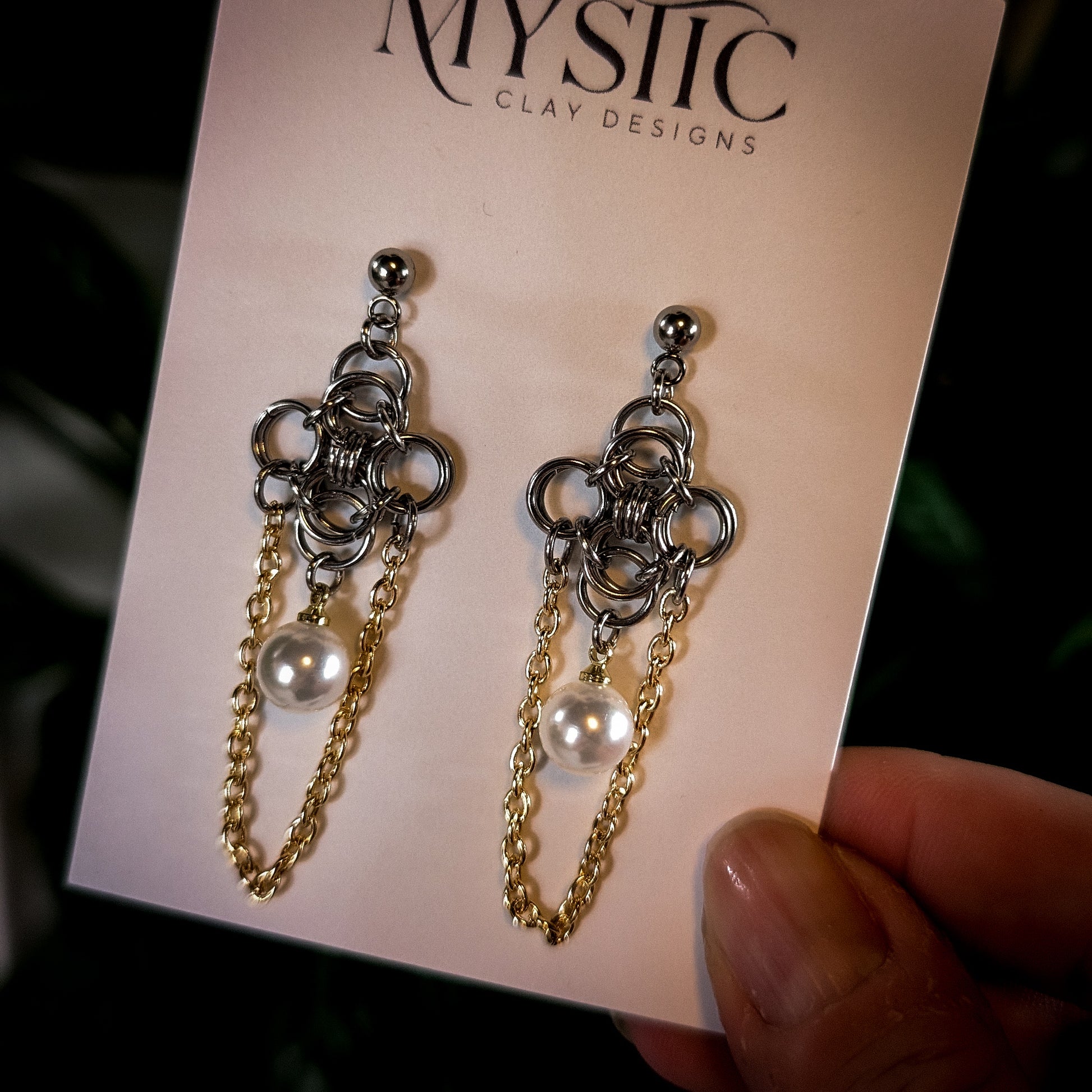 Pair of silver and gold chain earrings on a 'Mystic Clay Designs' card.