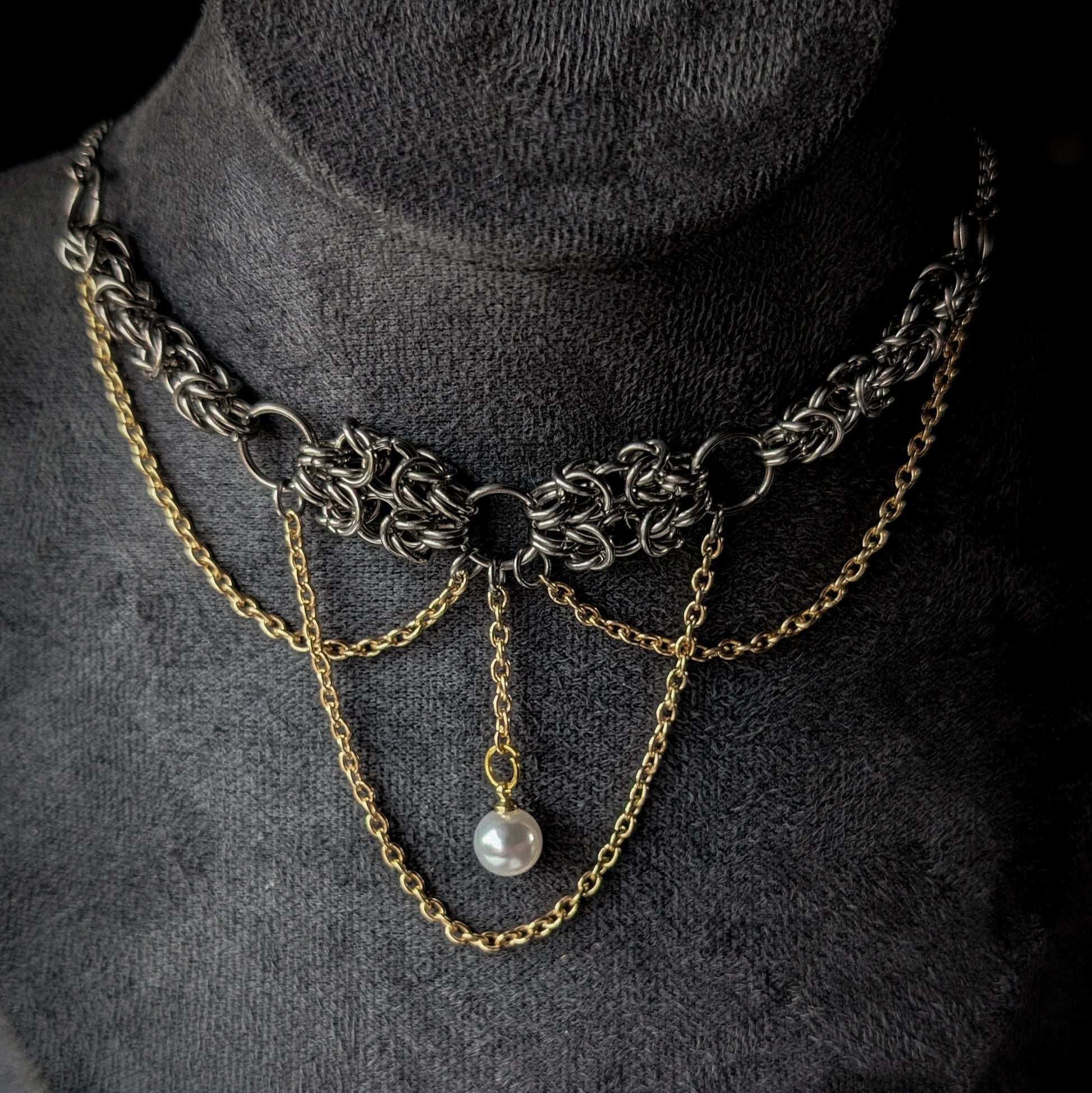Necklace with chains and a pearl on a dark background