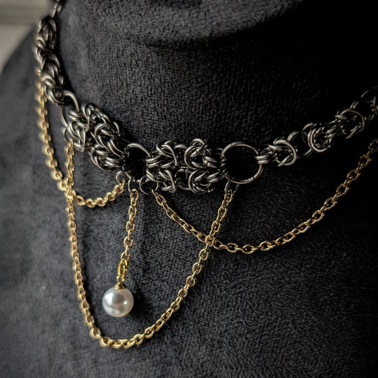 Necklace with chain and pearl on a dark background