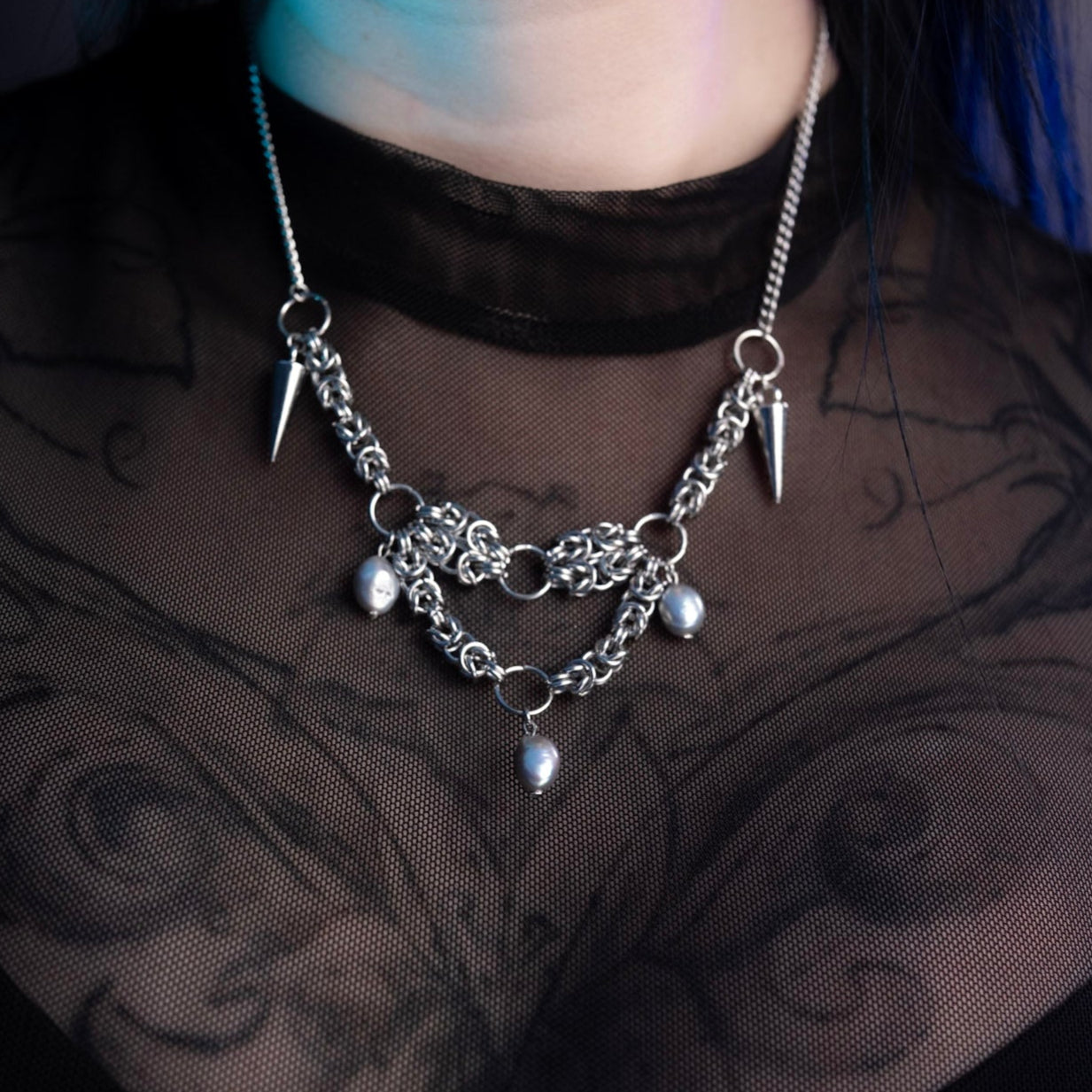 Necklace with spikes and pendants on a dark background