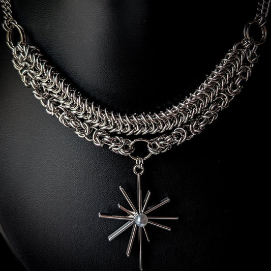 Silver chain necklace with a star-shaped pendant on a black background